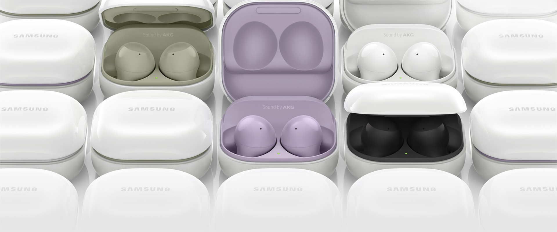Galaxy Buds2 cases are placed next to each other. Several of the cases are opened, each showing different colors of the inside case, from olive green, lavender, white, to black.