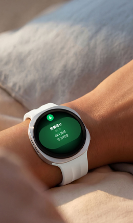 画面中，一个身影安睡于床榻，其腕间佩戴着一块Galaxy Watch9。画面呈现了一块Galaxy Watch9，设备屏幕弹出睡眠跟踪功能界面；佩戴者嘴角噙着浅淡笑意，直观传递出睡眠指导功能有效优化其睡眠模式与作息习惯，带来恢复效果更好的深度休憩体验。