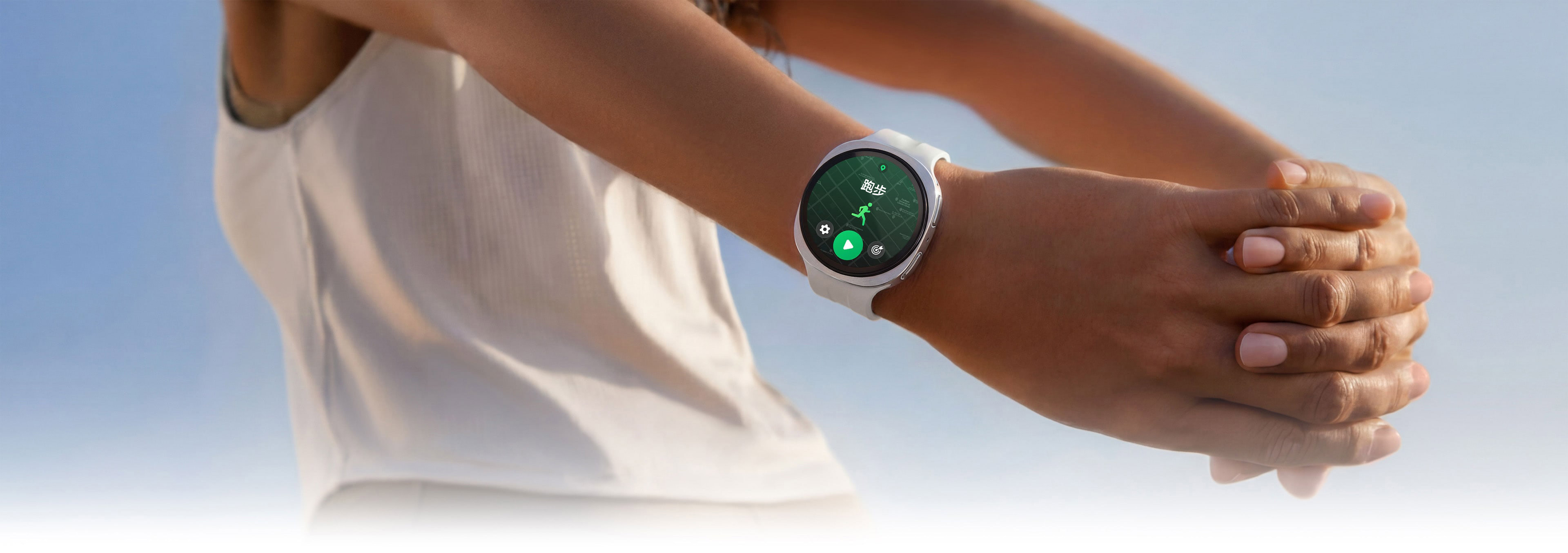 画面中的人物正在开展手臂拉伸动作，手腕处佩戴远空银色Galaxy Watch9，这款手表搭配白色运动表带。手表屏幕显示正在执行的跑步训练界面。