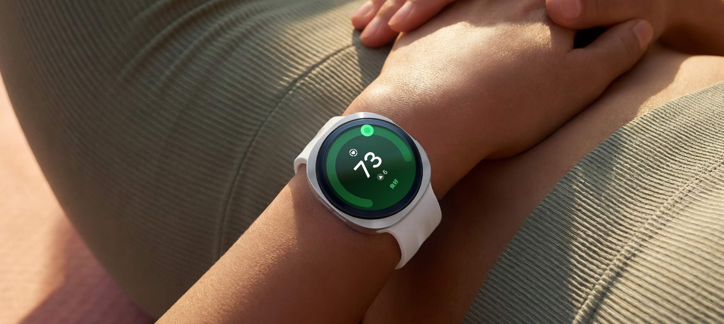 画面中的人物呈仰卧姿态，手腕佩戴远空银色Galaxy Watch9，这款手表搭配白色运动表带。屏幕实时显示心脏健康73分，直观展示了Galaxy Watch9搭载的心脏健康监测跟踪功能。