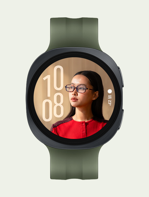 橄榄色运动表带款 Galaxy Watch9，展示正面全景与倾斜特写两种视角；手表搭载自定义人像表盘，时间显示在左侧，天气信息显示在右侧，界面内容不会遮挡人像面部。
