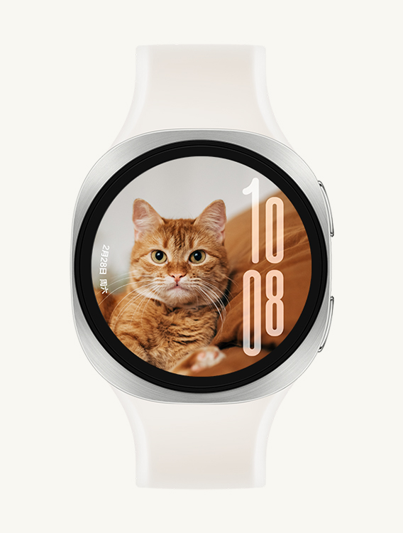 配备白色雾面表带的 Galaxy Watch9，展示正面视图与斜角度特写视图；手表使用自定义人像表盘，日期显示在左侧，时间显示在右侧，文字界面不会遮挡猫咪的脸部图案。