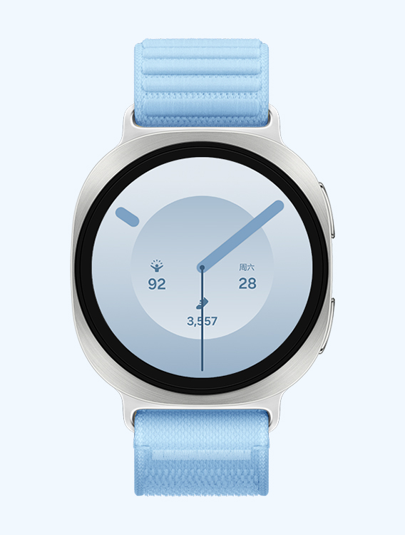 搭配蓝色织物表带的 Galaxy Watch9，展示正面视图与斜向特写视图，表盘可显示时间、精力评分、日期以及步数等信息。